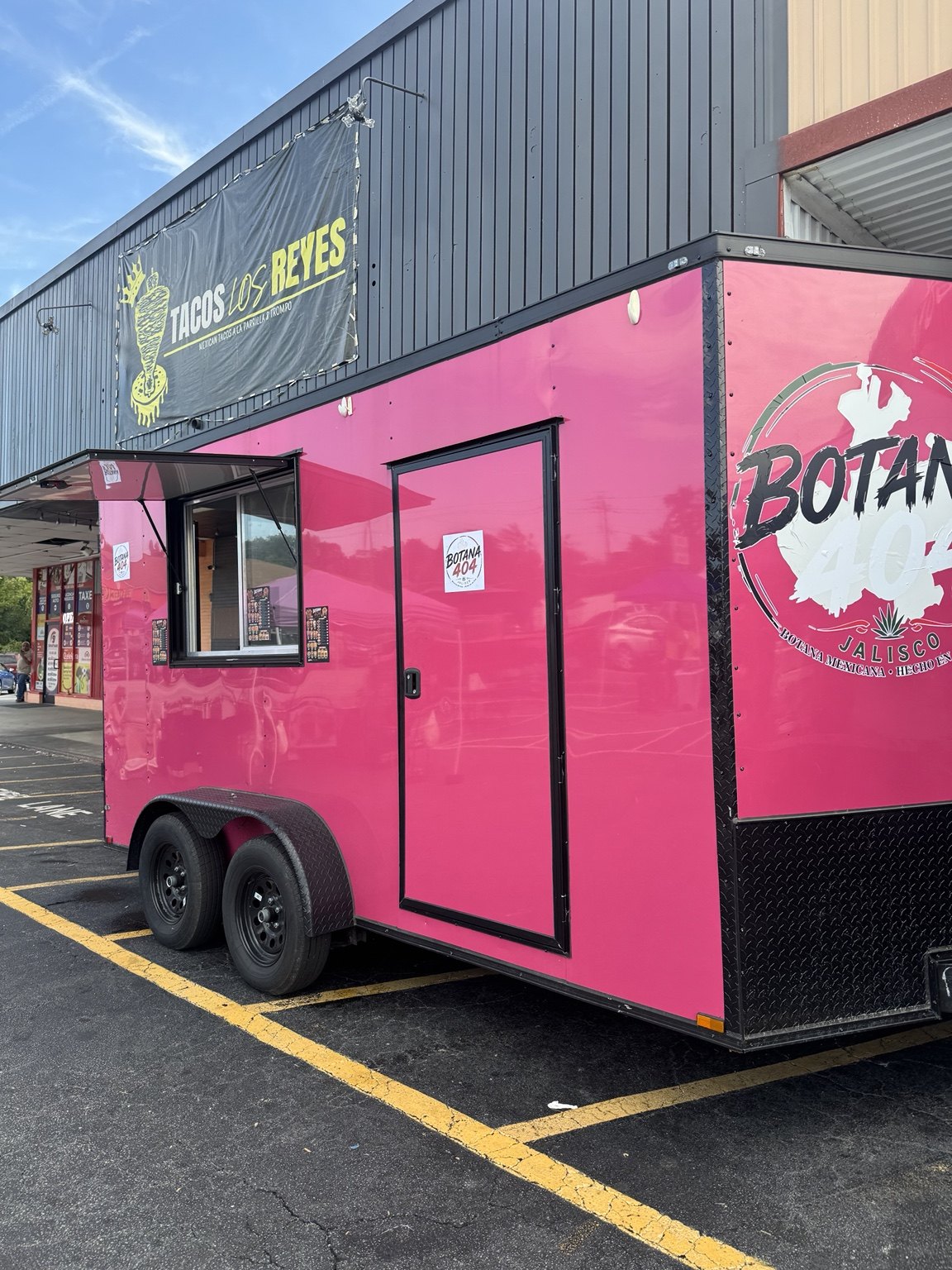 Bright pink Botana 404 food trailer with its serving window open